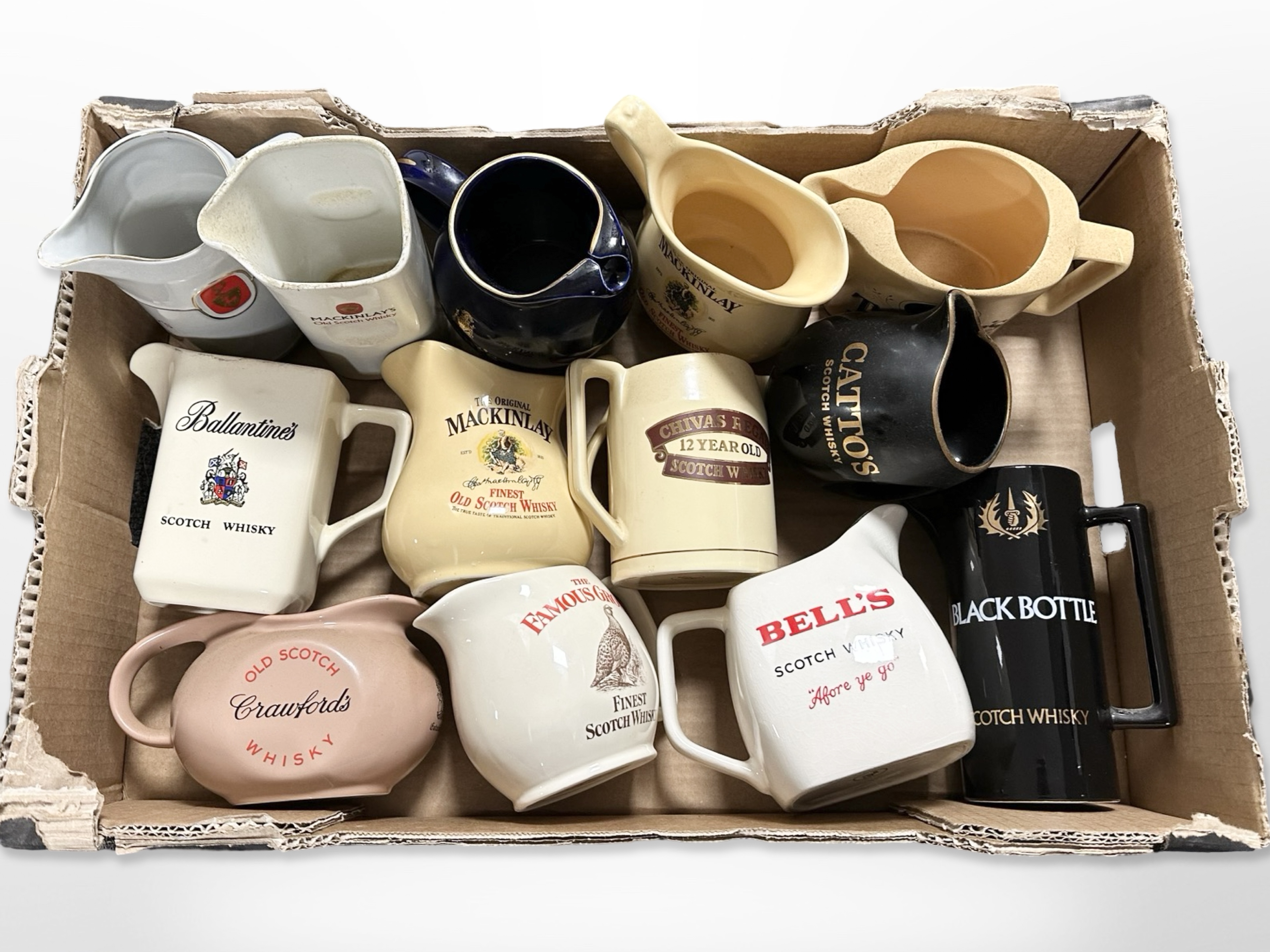 A collection of ceramic whisky jugs bearing various advertising.