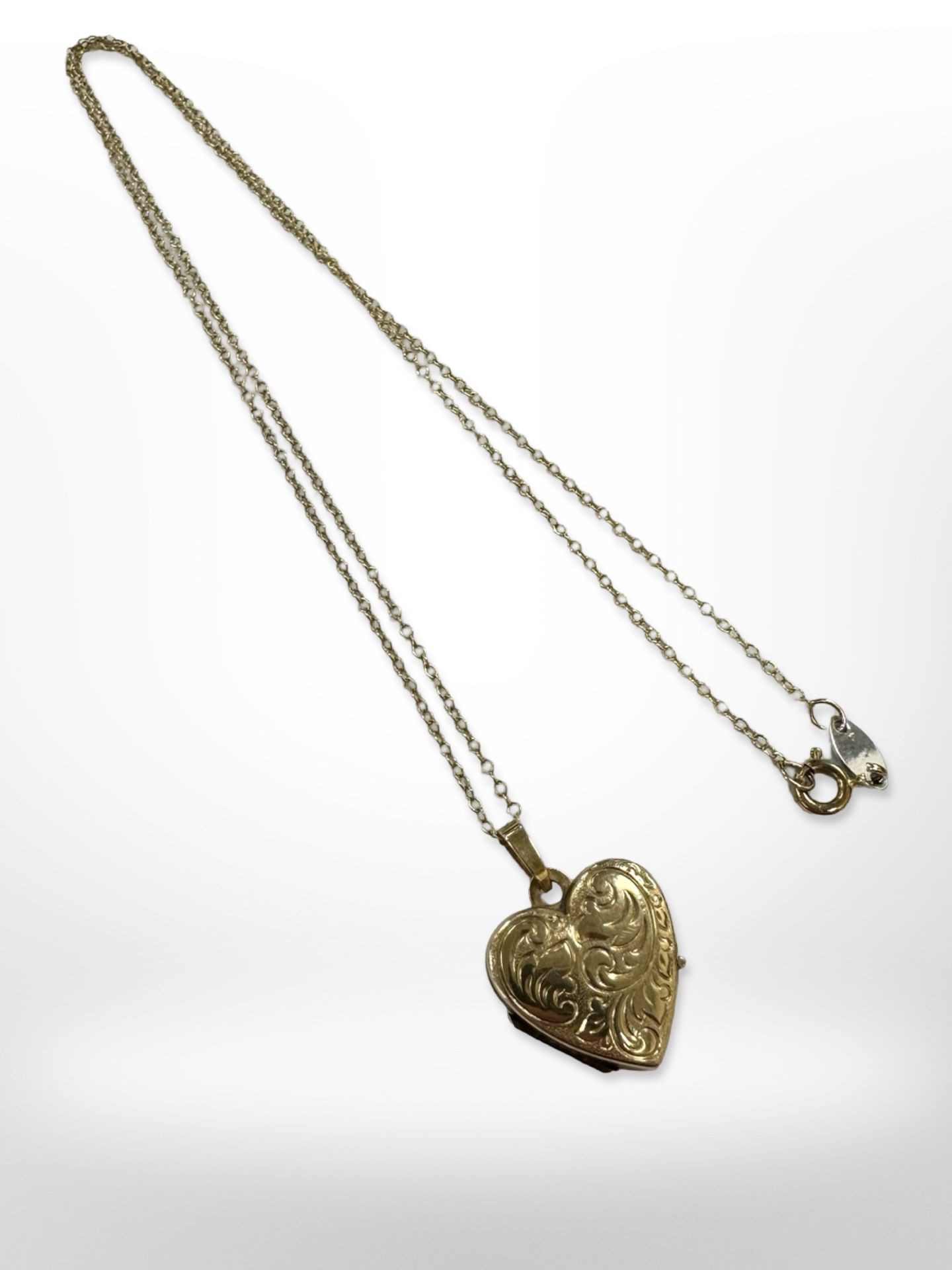 A 9ct yellow gold heart pendant suspended on a silver and gold plated chain.