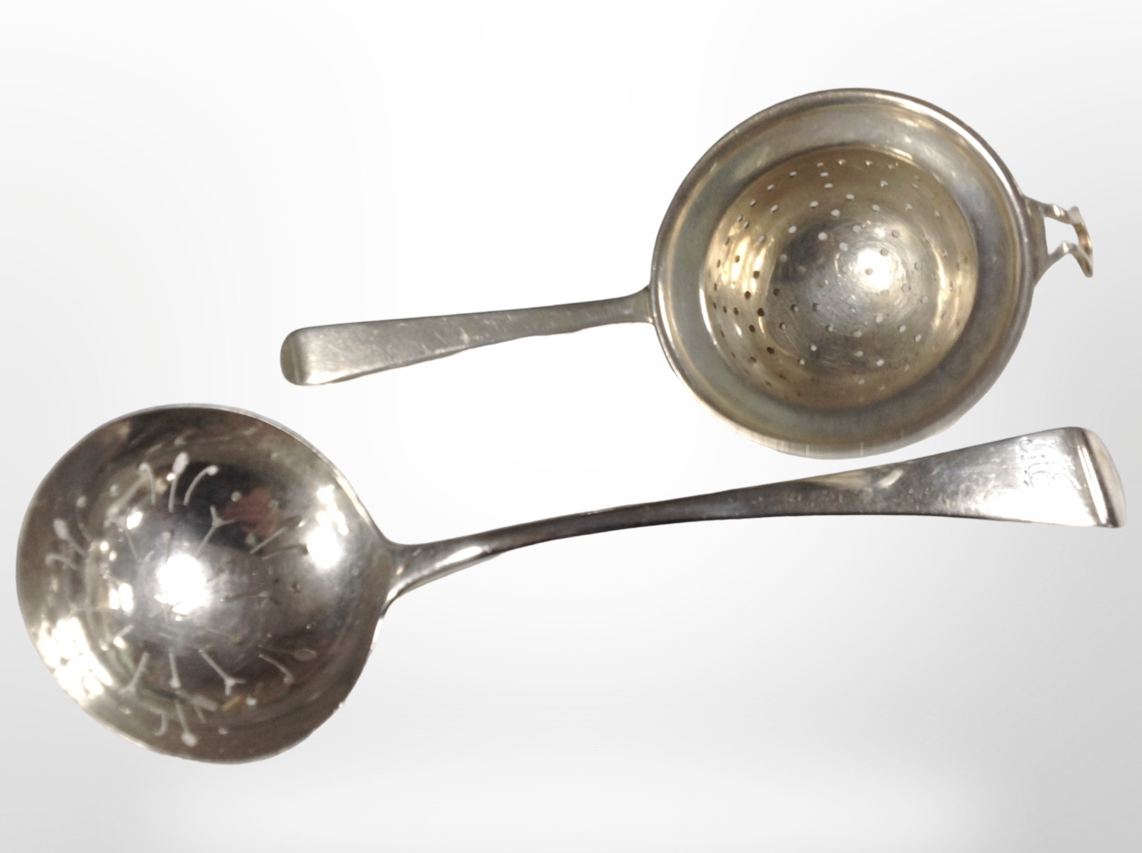 A George III silver straining spoon, length 17.5cm, together with another silver example.