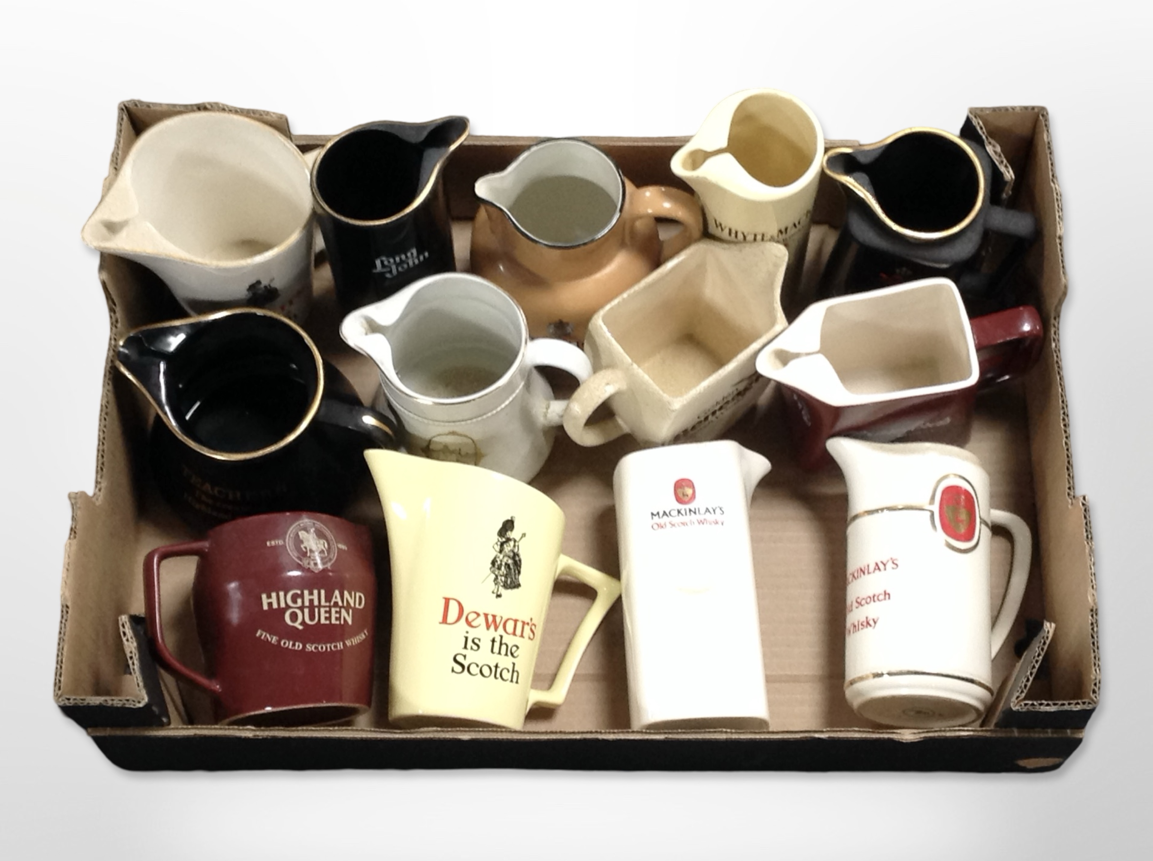 A collection of ceramic whisky jugs bearing various advertising.