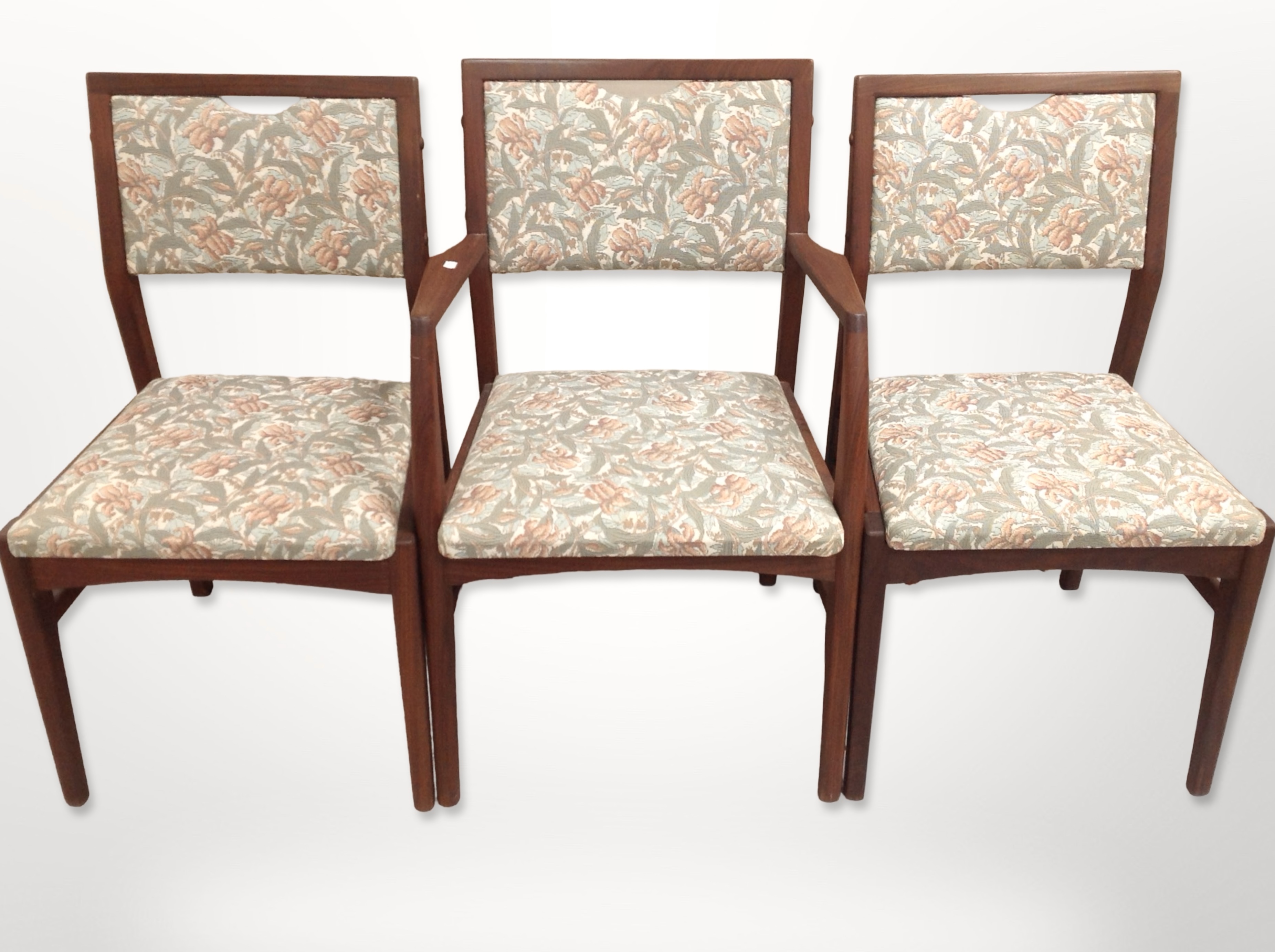 Six contemporary teak framed dining chairs in floral upholstery