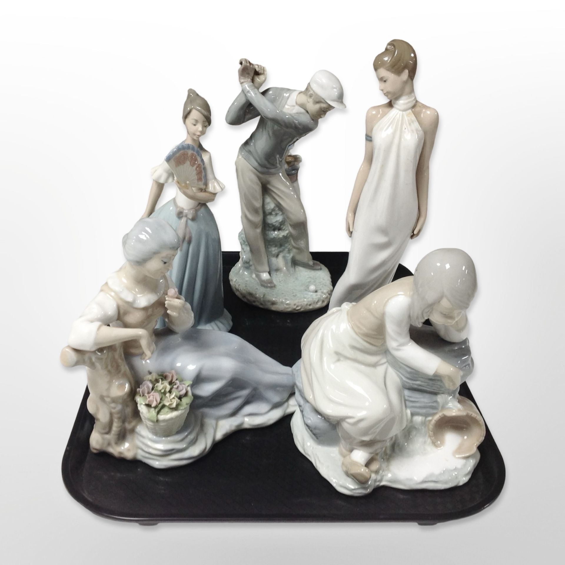 A Lladró figure of a golfer and three Nao figures of ladies and a further Spanish figure of a lady.