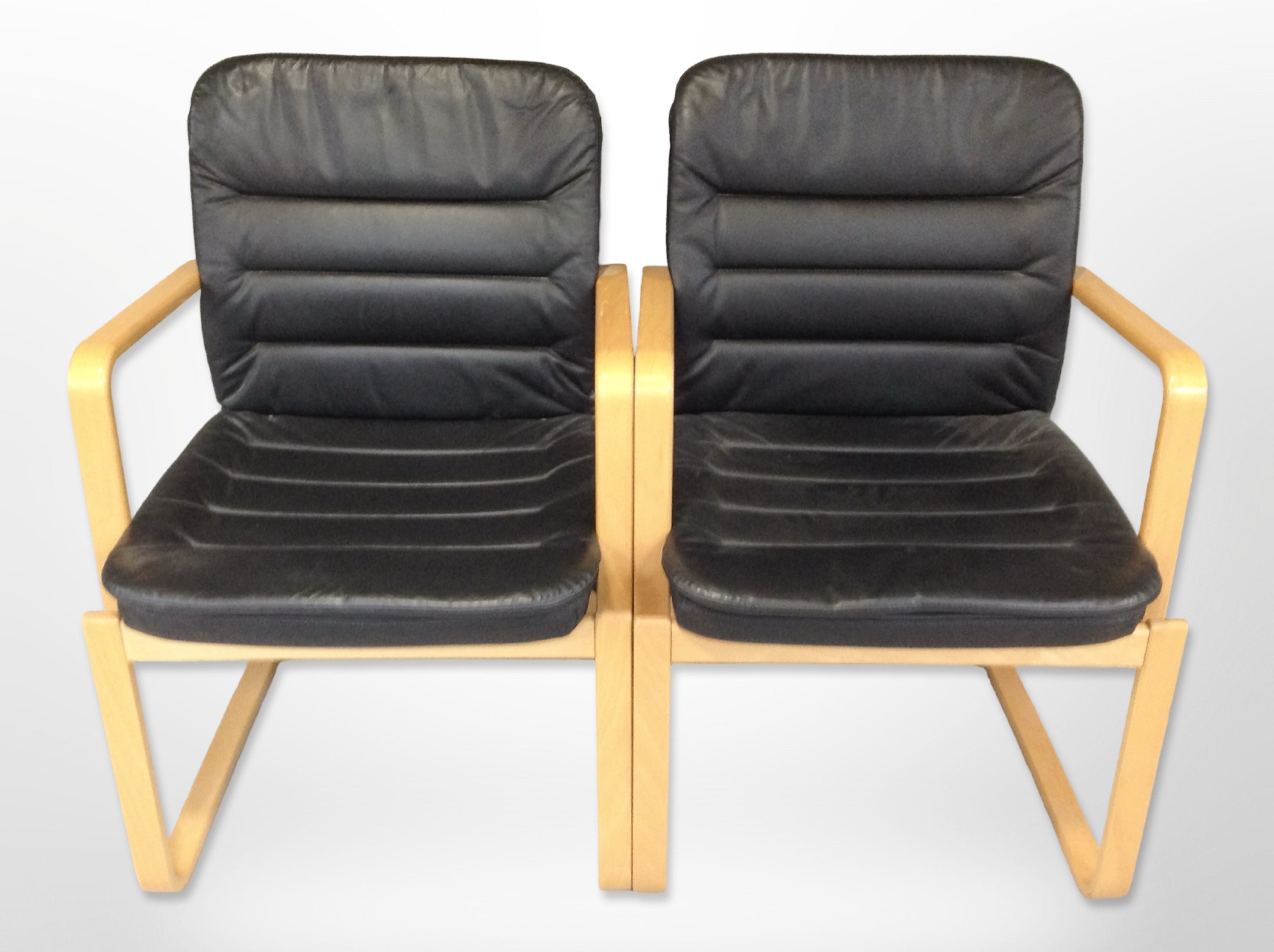 A pair of Kinnarps bentwood and black stitched leather armchairs,