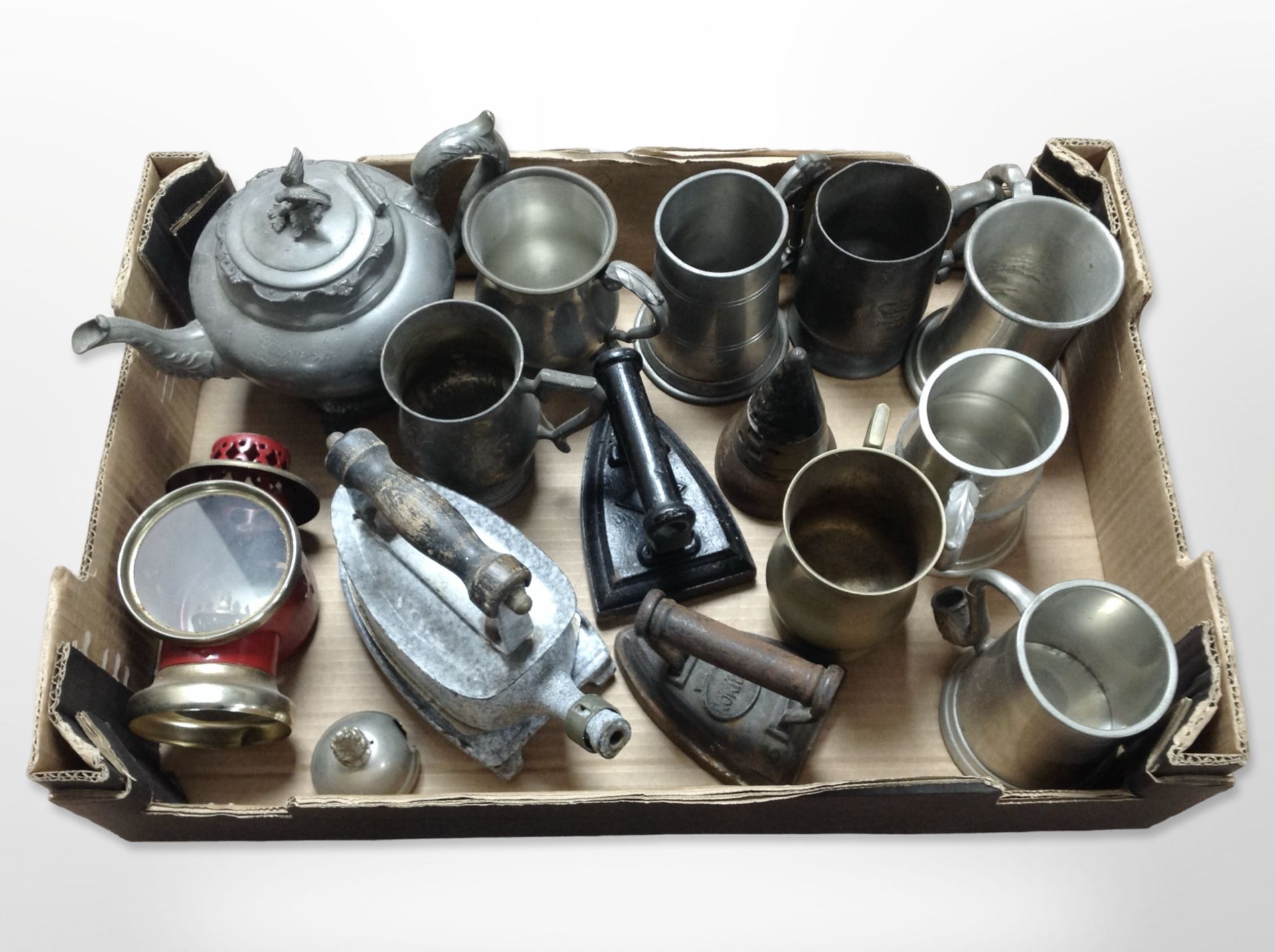 A group of metal wares including 19th-century pewter teapot and tankards, irons,