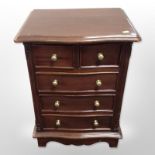 A reproduction mahogany serpentine fronted five drawer chest,