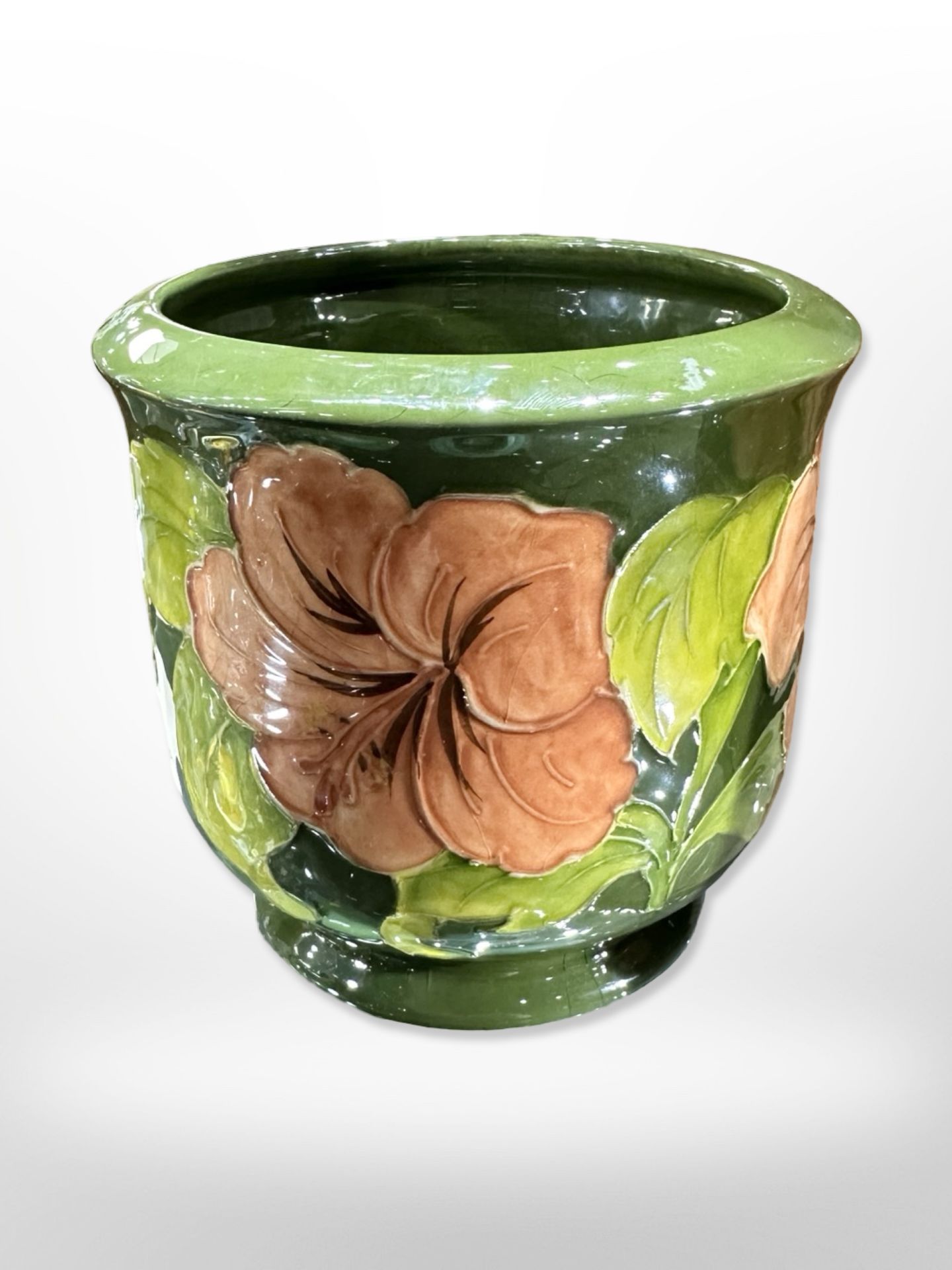 A Moorcroft plant pot on green ground, height 12.5cm.