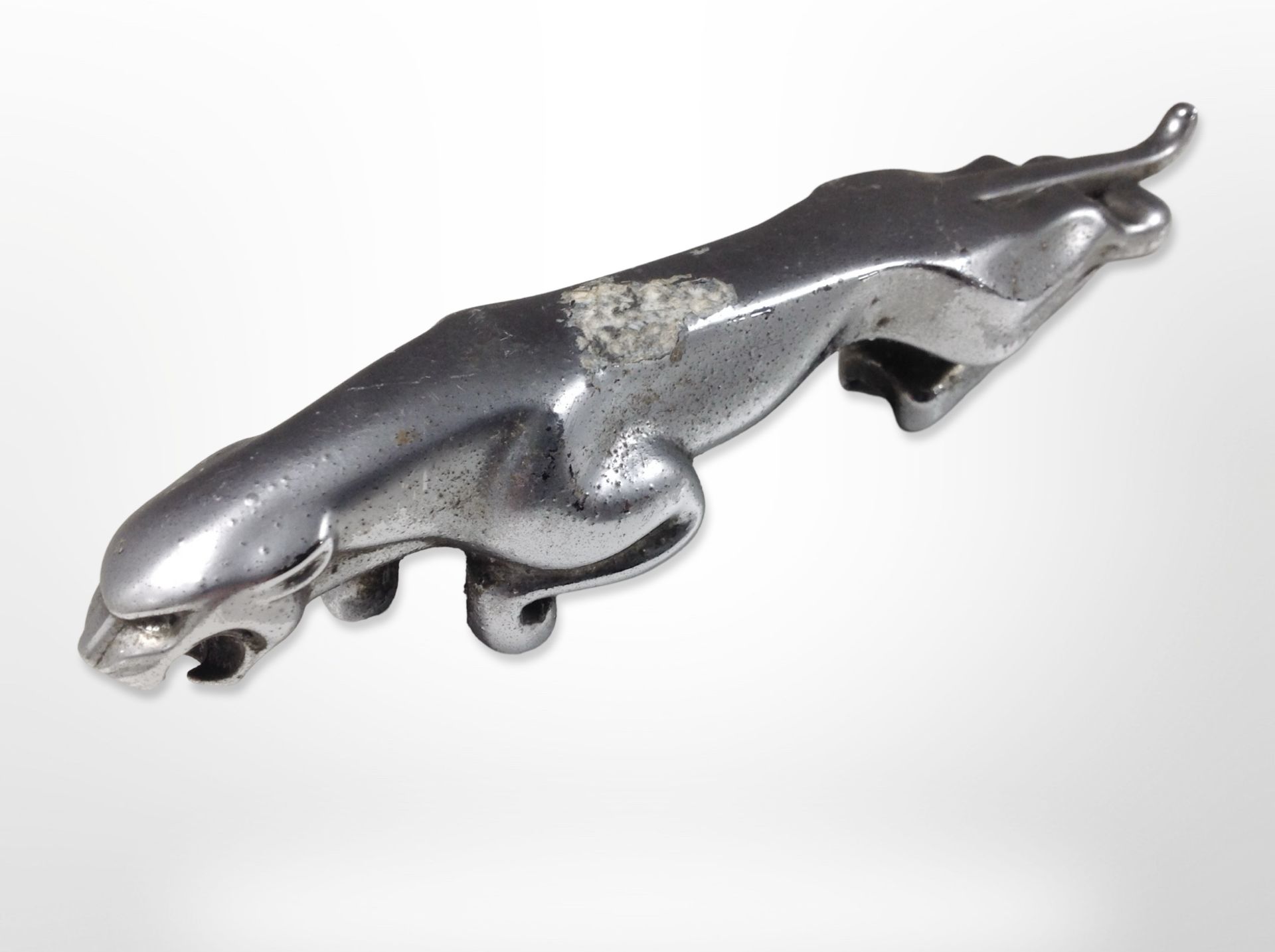 A chrome-plated die-cast metal Jaguar mascot, length 19.5cm.