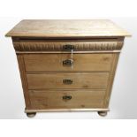 An early 20th century Scandinavian pine four drawer chest on bun feet,