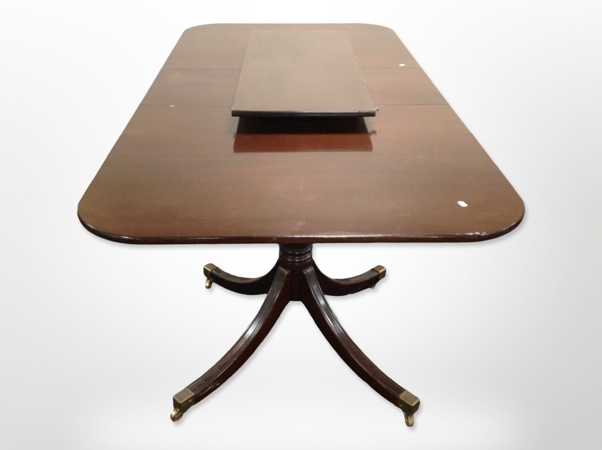 A reproduction mahogany twin-pedestal extending dining table with two leaves,