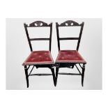 A pair of Edwardian ebonised occasional chairs with ER 1902 carved to the back rests