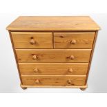 A contemporary pine five drawer chest,