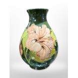 A Moorcroft bulbous vase on green ground, height 20.5cm.