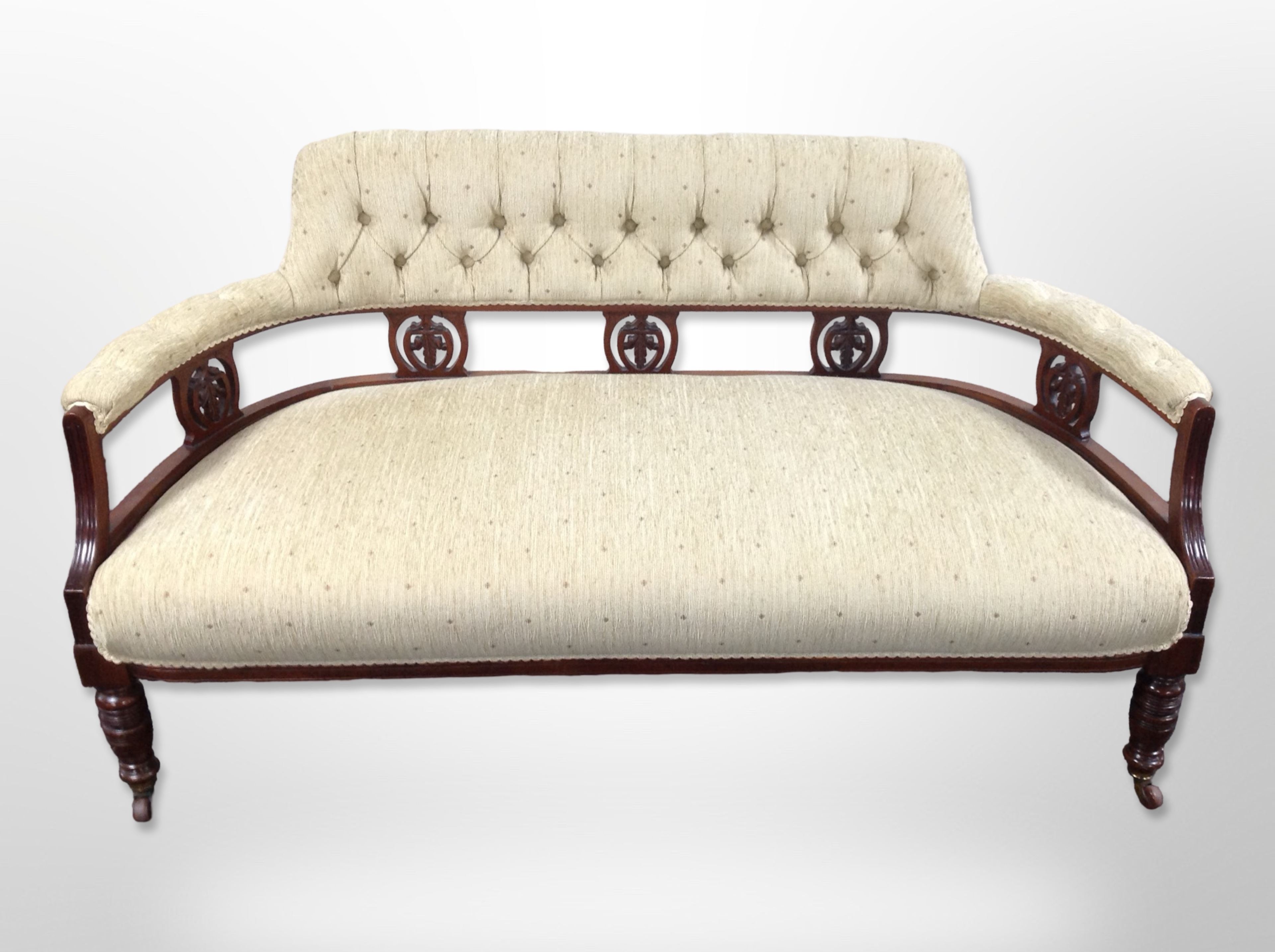An Edwardian walnut framed salon settee in buttoned upholstery 142 cm long x 71 cm deep x 76 cm