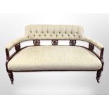 An Edwardian walnut framed salon settee in buttoned upholstery 142 cm long x 71 cm deep x 76 cm