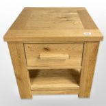 A contemporary light oak single-drawer lamp table, 50cm wide x 50cm high x 50cm deep.