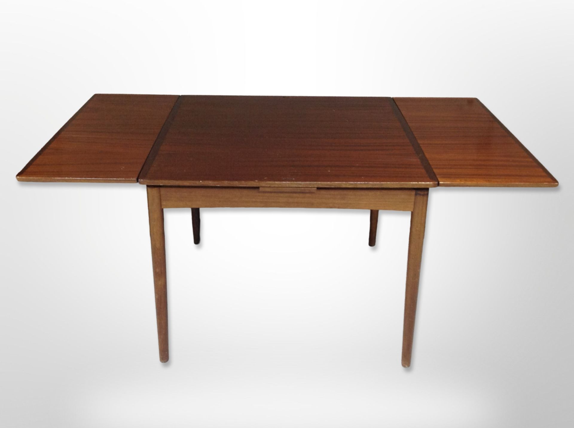 A late 20th century Danish teak pull out extending dining table,