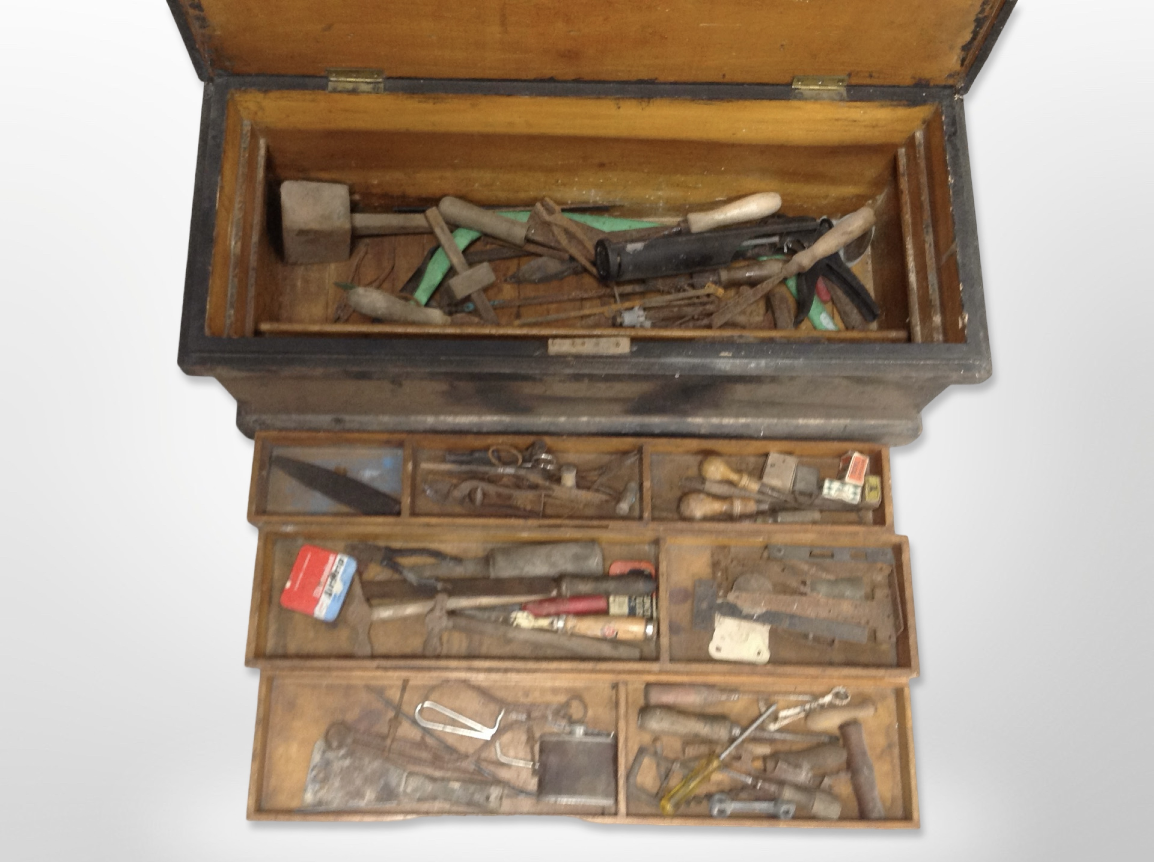 An antique pine joiner's tool box containing assorted carpentry tools