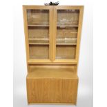 A late 20th century Danish oak veneered glazed bookcase with cupboards beneath,