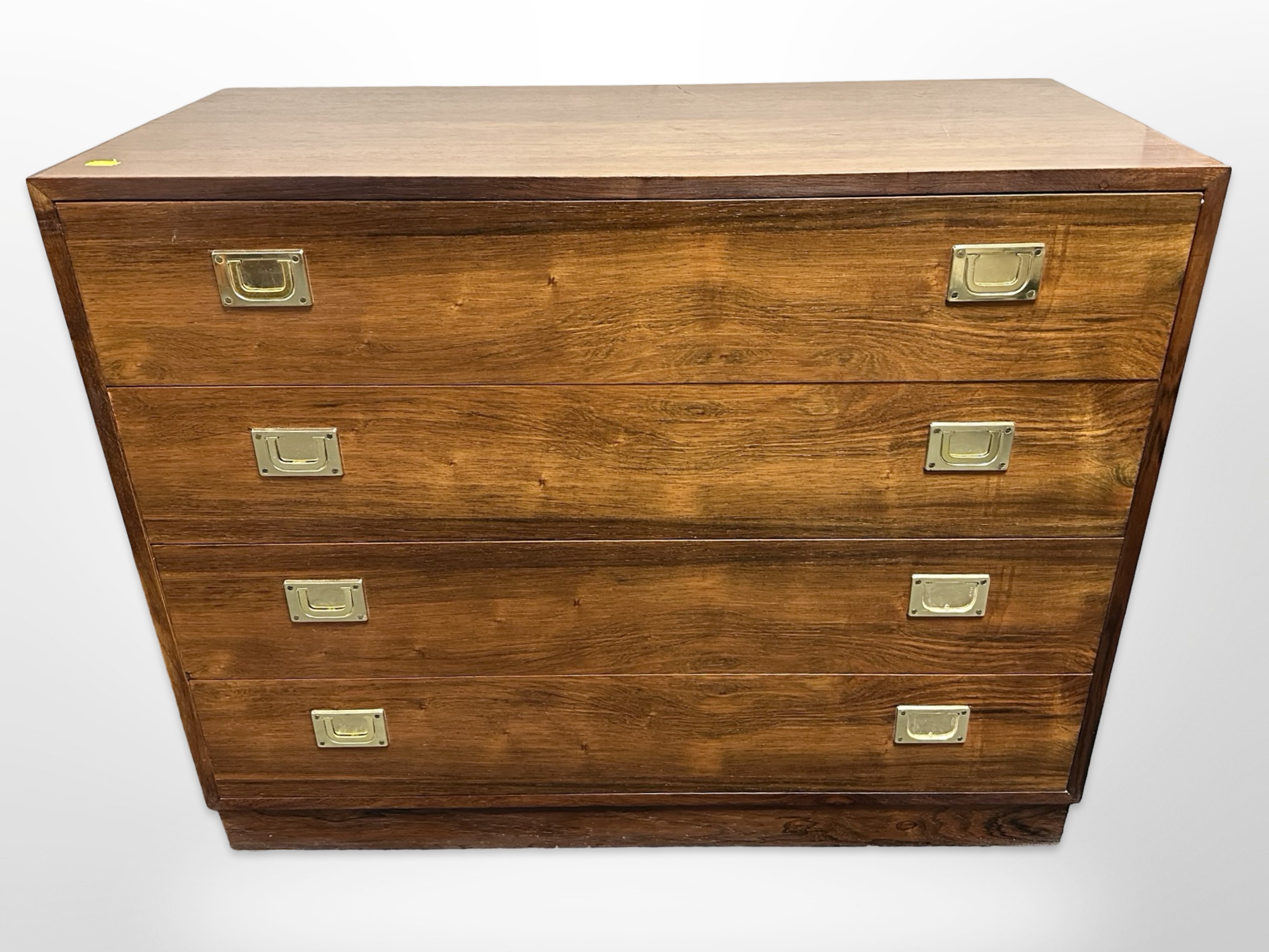 A late 20th century Danish teak campaign style four drawer chest with brass drop handles,