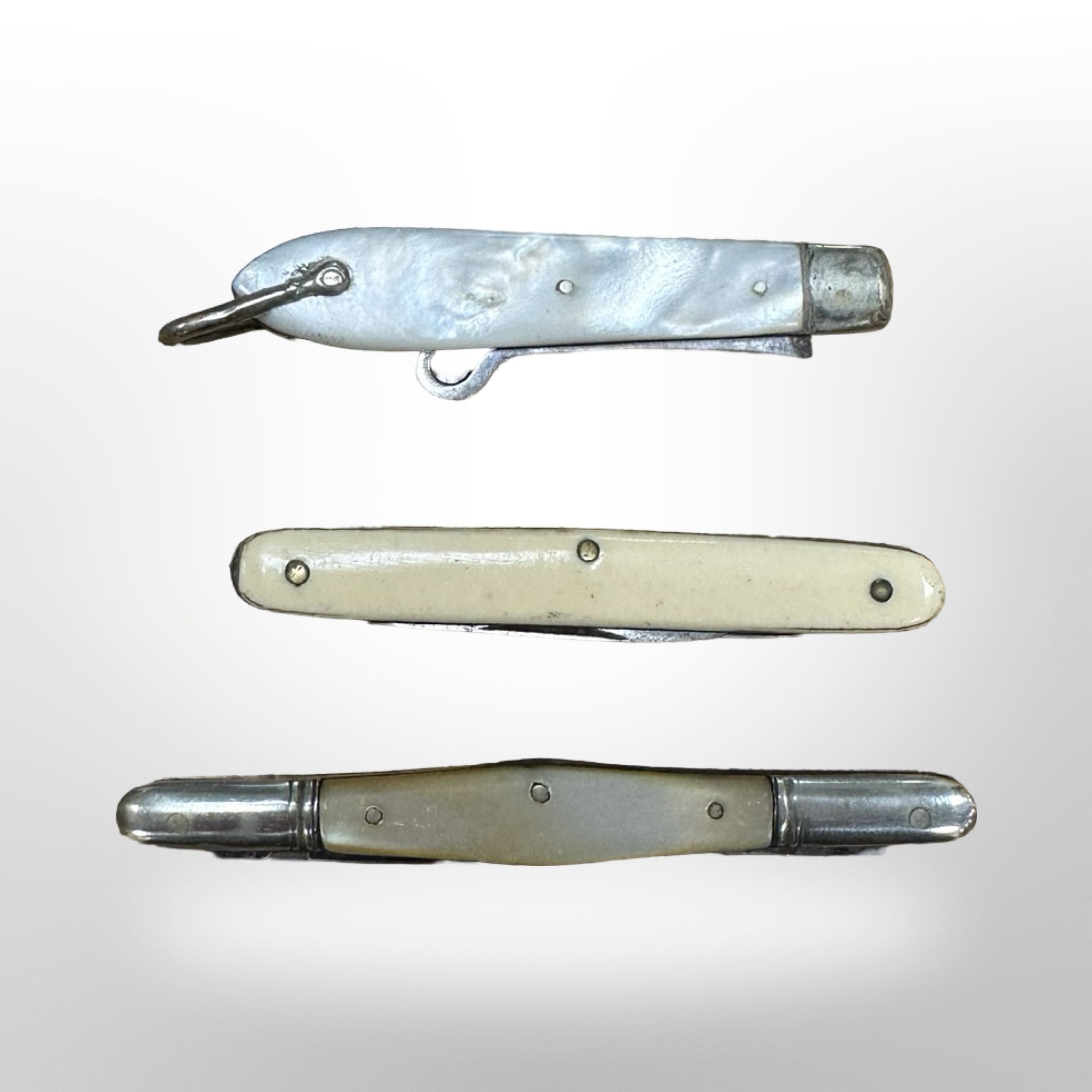 A silver and mother of pearl hook together with two further miniature folding pen knives (3)