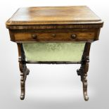 An early-Victorian carved rosewood fold-over top sewing table, raised on brass castors,