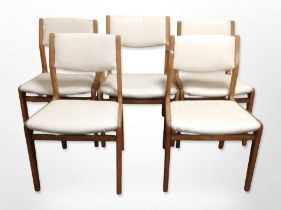 A set of five 20th century teak-framed dining chairs with cream vinyl seats and back rests.
