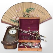 An Hermle wall clock, together with a large oriental hand fan, two decorative swords,