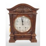 A carved oak eight day bracket clock, with silvered dial signed Curtis and Horspool, Leicester,