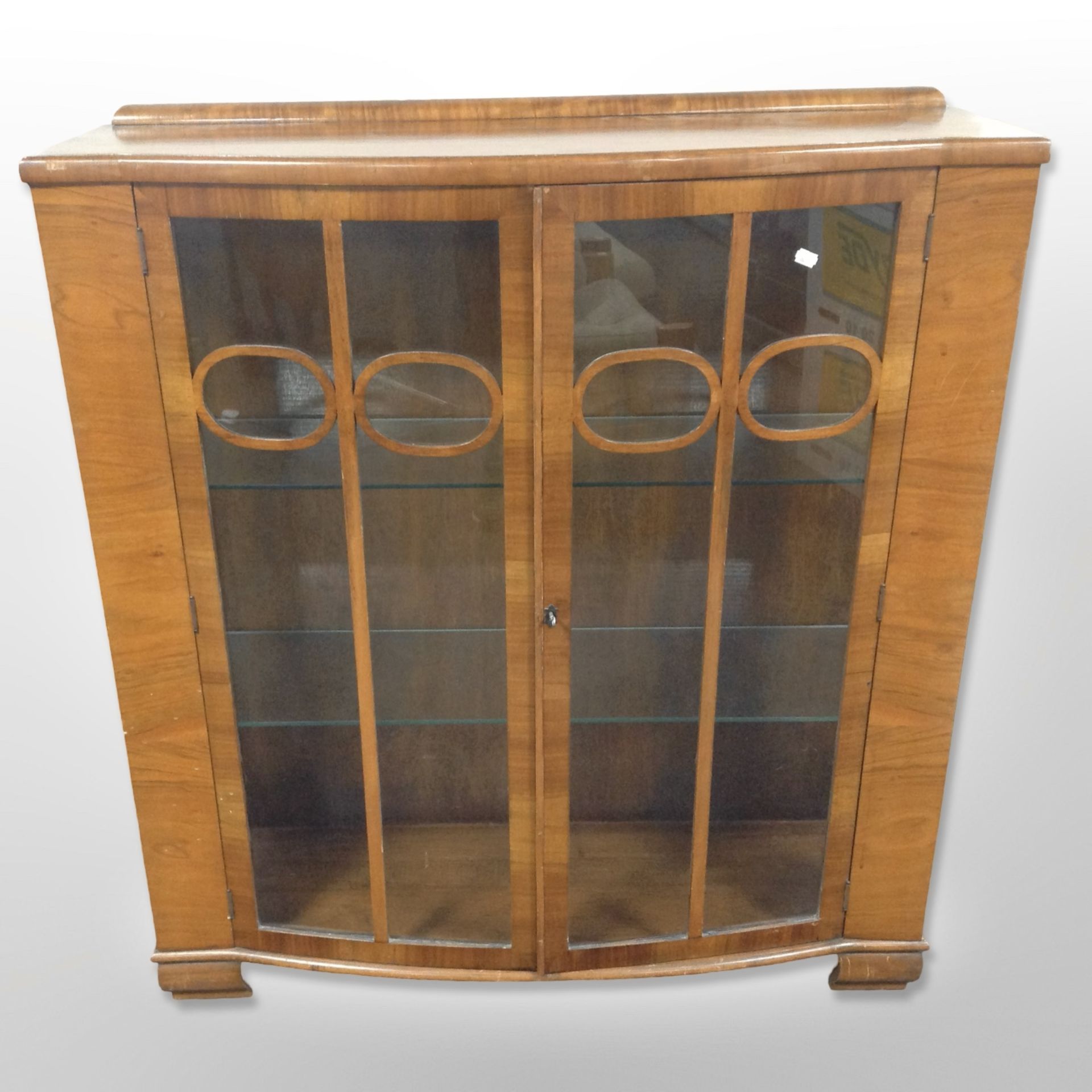 An Art Deco walnut bow-front display cabinet, 105cm wide x 35cm deep x 117cm high.