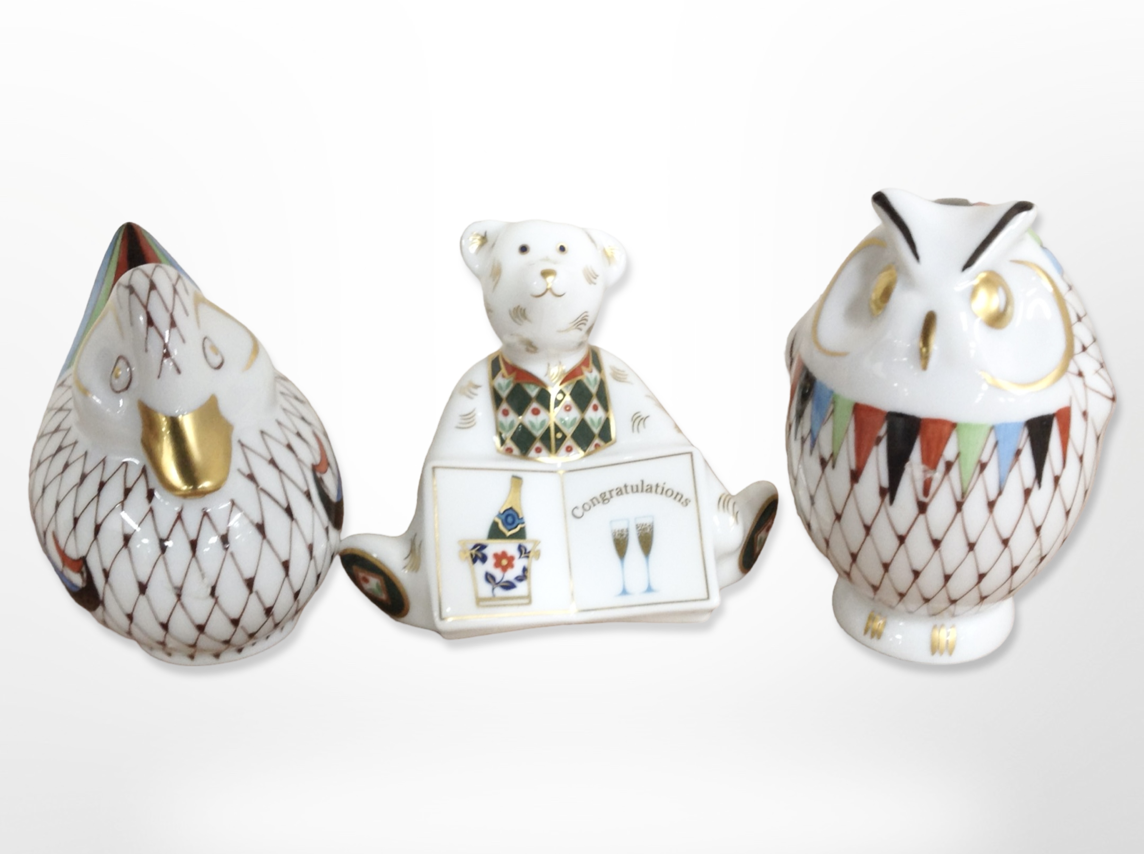 A Royal Crown Derby porcelain teddy bear paperweight, and two Hungarian Hollohaza paperweights,
