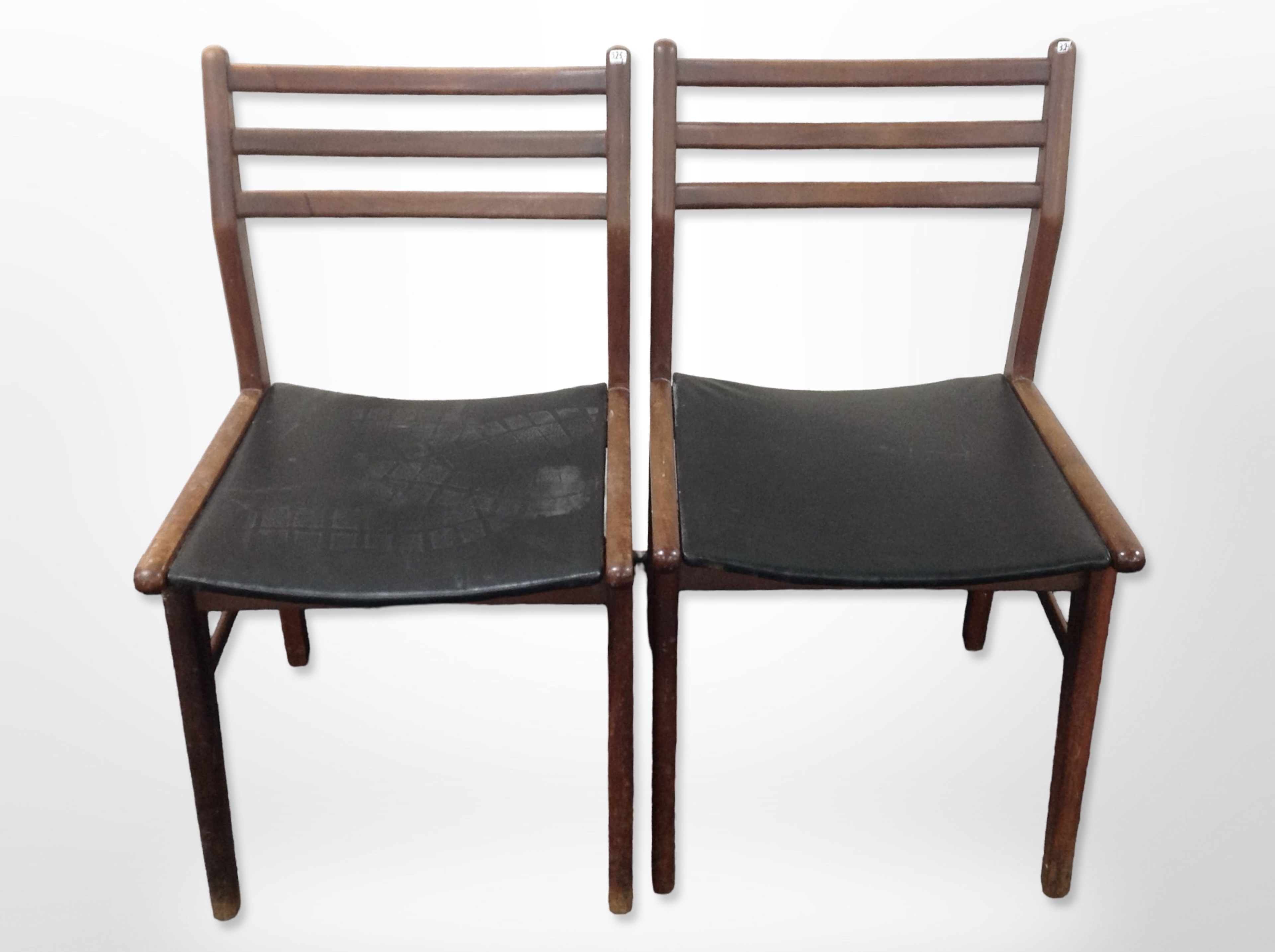 A pair of 20th-century Danish teak and black vinyl ladder back dining chairs.