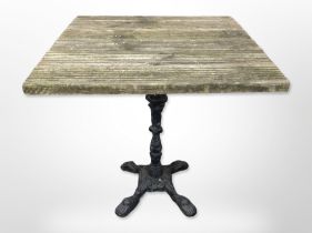 A square teak-topped table on cast-iron pedestal, width 73cm.