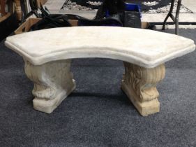 A concrete curved garden bench on classical style pedestals,