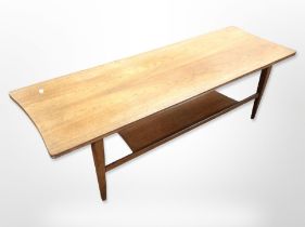 A 20th-century teak shaped rectangular top two-tier coffee table on tapered legs,