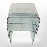 A contemporary nest of three ghost glass tables, width 55cm.