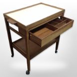 A 20th-century teak and melamine two-tier serving trolley, with lift-off twin-handled tray top,