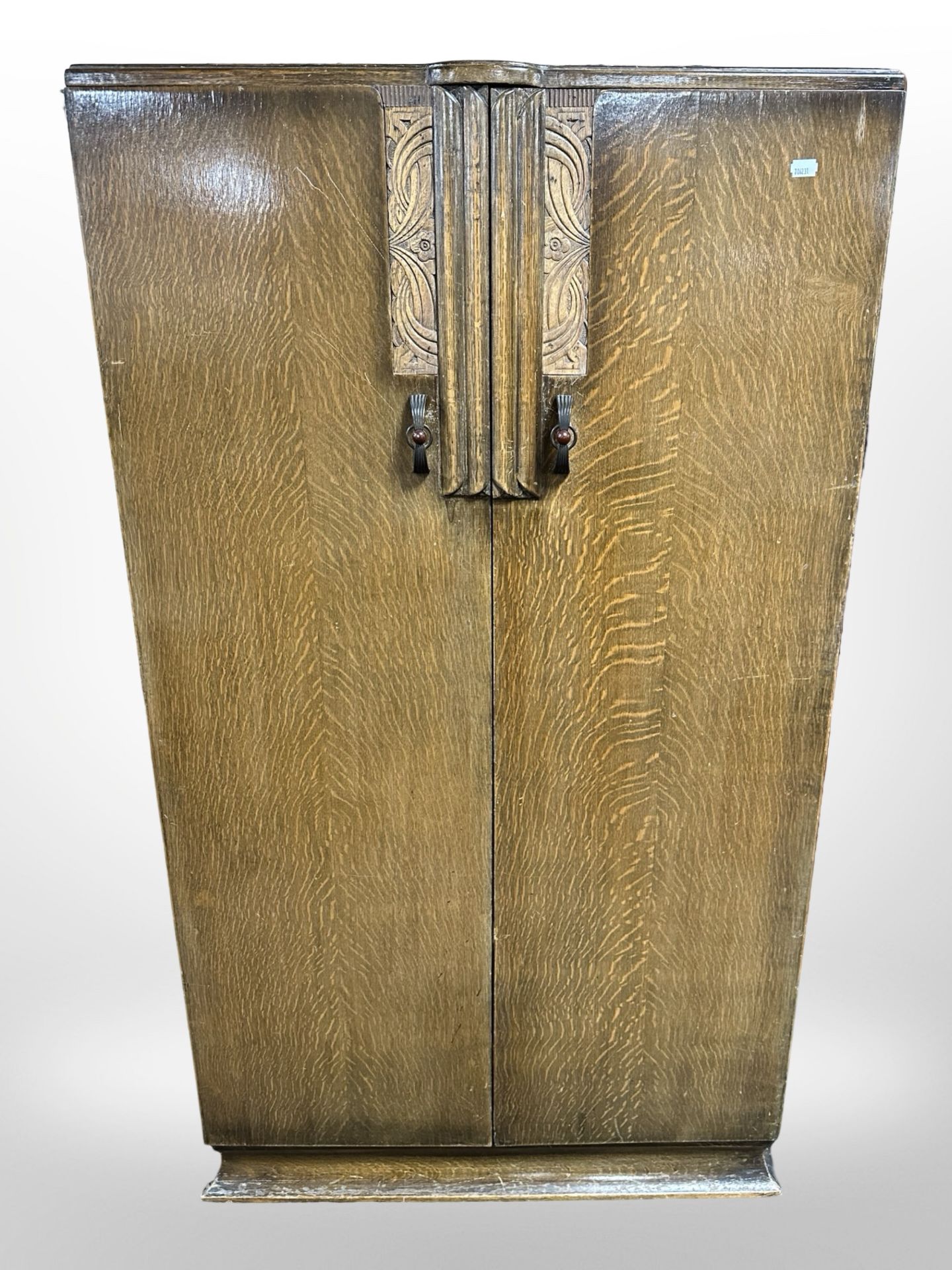 A 1930s carved oak double-door linen cupboard, 76cm wide x 48cm deep x 132cm high.