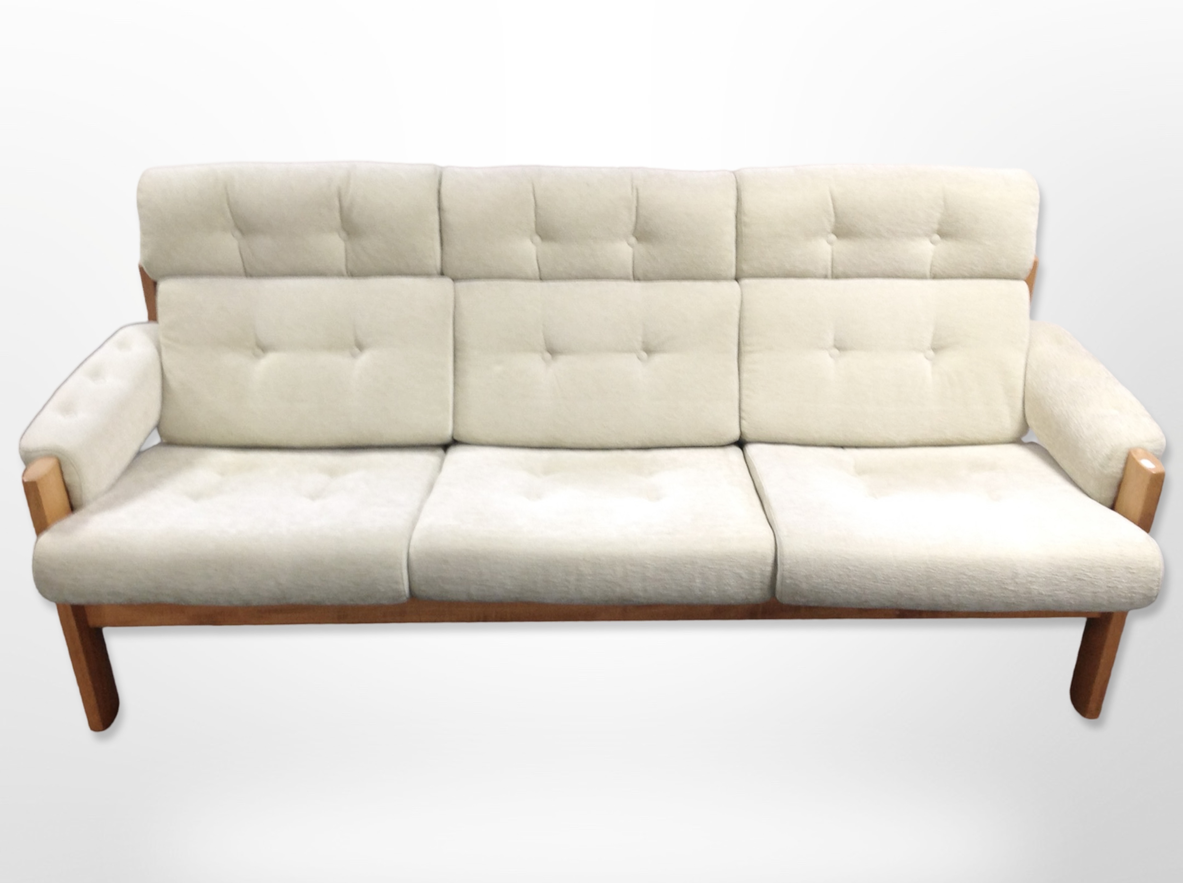A 20th-century wooden-framed three-piece lounge suite, in buttoned beige upholstery,