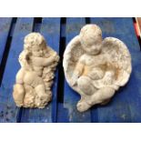 Two concrete cherub garden figures,