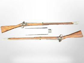 A pair of reproduction non-firing flintlock muskets, each 148cm long, with two bayonets.