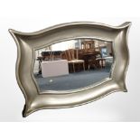 A large contemporary overmantle mirror in swept silvered frame, 134cm wide x 96cm high.