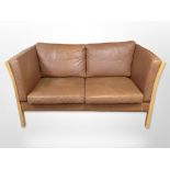 A late-20th century Danish brown stitched leather two-seater settee, with beech frame,