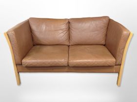 A late-20th century Danish brown stitched leather two-seater settee, with beech frame,