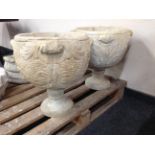 A pair of circular twin-handled concrete urns,