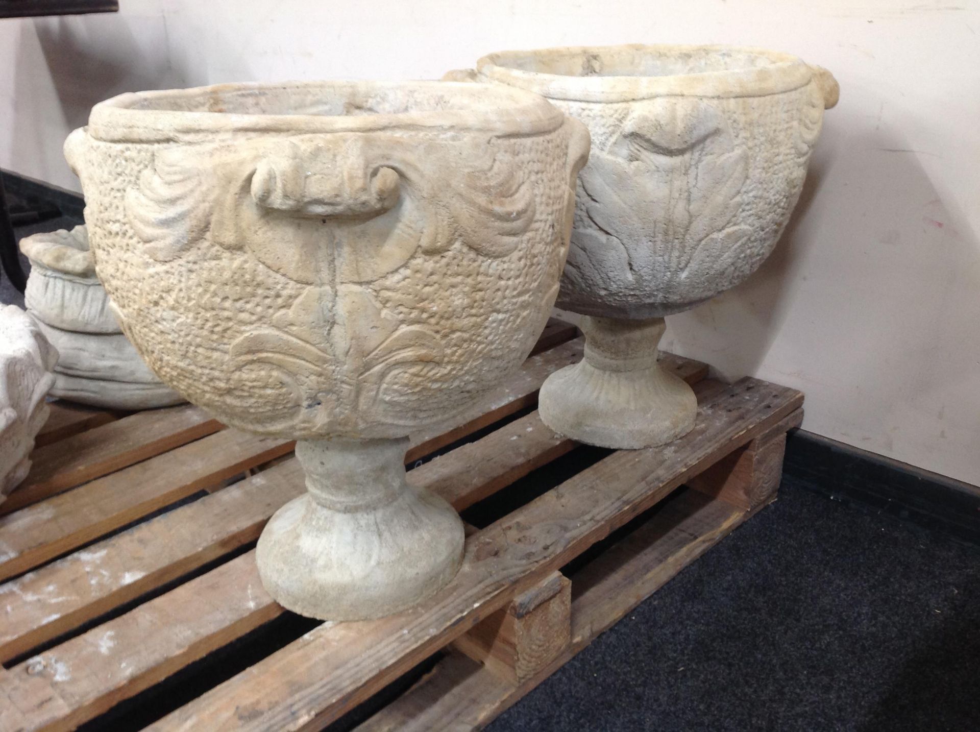 A pair of circular twin-handled concrete urns,