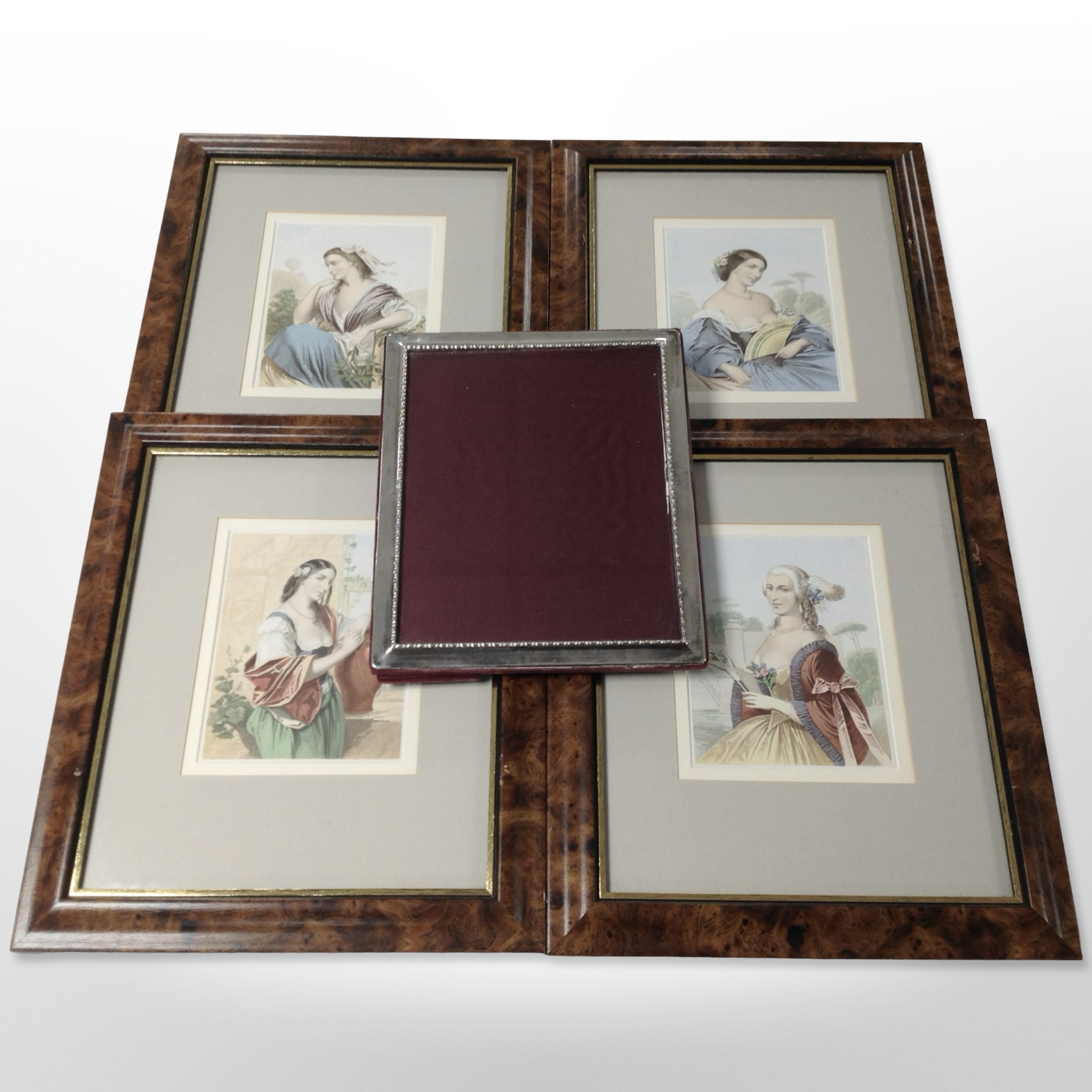 A set of four colour lithographs of ladies in burr walnut-effect frames, 40cm x 35cm overall,