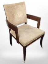 An early 20th-century mahogany-framed armchair on brass castors, width 65cm.
