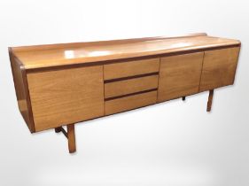 A 20th-century teak low sideboard fitted three cupboards and three drawers,