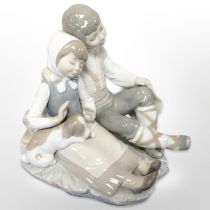 A Lladró figure group of a boy, girl and puppy.