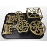 Four brass trivets and a pair of Art Nouveau brass wall candle sconces.